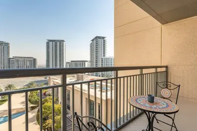 a balcony with a table and a view of the city at PVH - Creek Residences South T3 - Harbourfront 2BR in Dubai