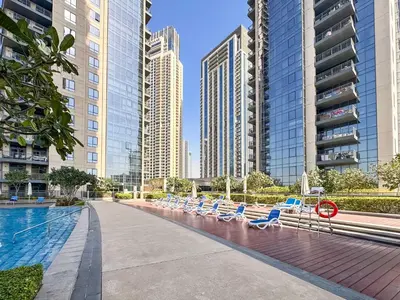 a swimming pool with lounge chairs and tall buildings at PVH - Creek Residences South T3 - Harbourfront 2BR in Dubai