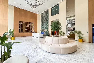 a large lobby with a white couch in the middle at PVH - Pristine 1BR Minutes to Circle Mall - Binghatti Amber in Dubai