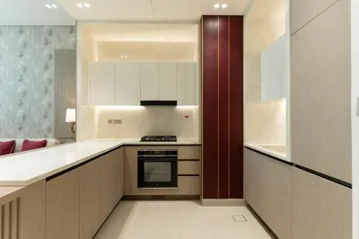 a kitchen with white cabinets and a stove top oven at Elegant Apartment with Balcony Pool & Parking in Dubai