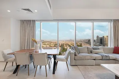 a living room with a couch and a table with chairs at Stylish 4BR with Burj & Fountain View, Dubai Mall Connection in Dubai