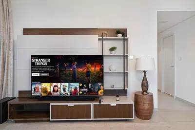 a living room with a flat screen tv on a entertainment center at Stylish 4BR with Burj & Fountain View, Dubai Mall Connection in Dubai