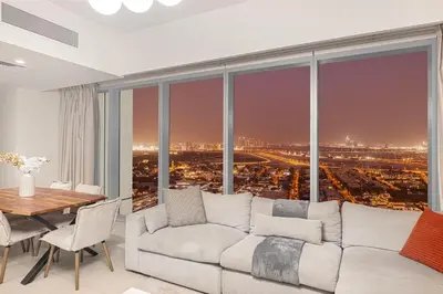 a living room with a couch and a large window at Stylish 4BR with Burj & Fountain View, Dubai Mall Connection in Dubai