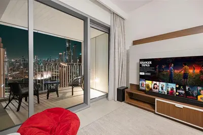 a living room with a flat screen tv and a balcony at Stylish 4BR with Burj & Fountain View, Dubai Mall Connection in Dubai