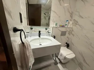 a white bathroom with a sink and a toilet at Chic Studio Living Elysee III by Pantheon in Dubai
