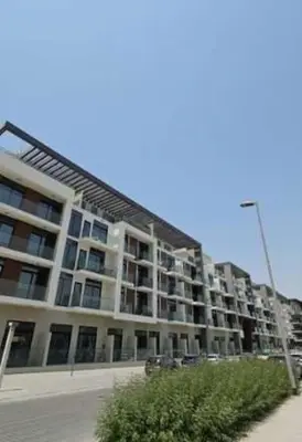 a large apartment building with cars parked in front of it at Chic Studio Living Elysee III by Pantheon in Dubai