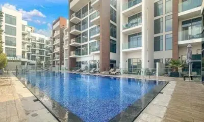 a large swimming pool in front of a building at Chic Studio Living Elysee III by Pantheon in Dubai
