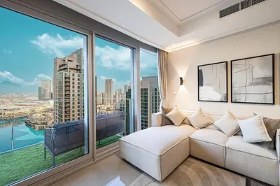 a living room with a couch and a large window at 4BR Penthouse Feel Featuring Stunning Burj And Fountain View in Dubai