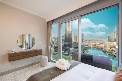 a bedroom with a bed and a large window at 4BR Penthouse Feel Featuring Stunning Burj And Fountain View in Dubai