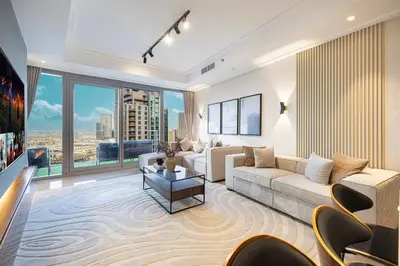 a living room with a couch and a large window at 4BR Penthouse Feel Featuring Stunning Burj And Fountain View in Dubai