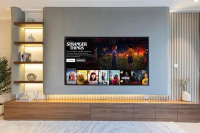 a tv hanging on a wall in a living room at 4BR Penthouse Feel Featuring Stunning Burj And Fountain View in Dubai