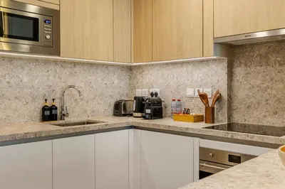 a kitchen with white cabinets and a microwave at Canal Stays in Dubai