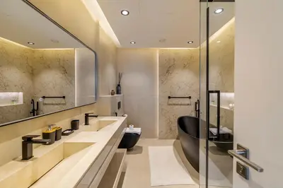 a bathroom with a black toilet and a sink at Canal Stays in Dubai
