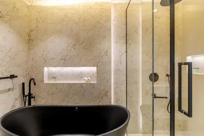 a bathroom with a black tub in a shower at Canal Stays in Dubai