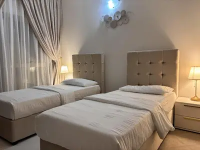 a bedroom with two beds and a window at Miraclema Stays Al Barsha 1 in Dubai