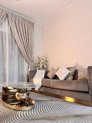 a living room with a couch and a table at Miraclema Stays Al Barsha 1 in Dubai