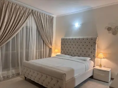 a white bedroom with a large bed and a window at Miraclema Stays Al Barsha 1 in Dubai
