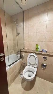 a small bathroom with a toilet and a shower at Miraclema Stays Al Barsha 1 in Dubai