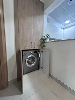 a laundry room with a washing machine in a room at High-Floor 1BR Escape - The Bay Rooftop Pool in Dubai