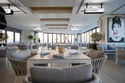 a restaurant with white tables and chairs and a sign that reads sunset at Luxury 2BR, Burj Khalifa View, Fully equipped, Top Amenities in Dubai