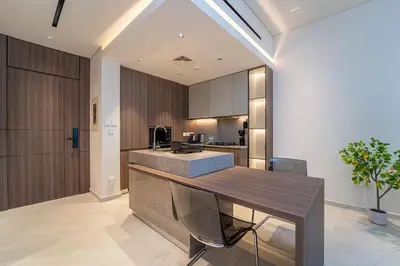 a kitchen with a wooden island in a room at Sleek New 1 Bed with Padel Court in Arjan in Dubai