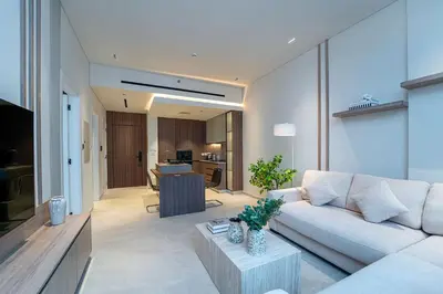 a living room with a white couch and a table at Sleek New 1 Bed with Padel Court in Arjan in Dubai
