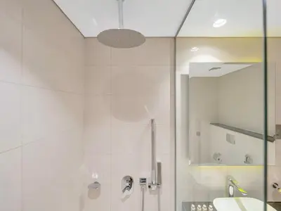 a white bathroom with a shower and a sink at NEW Noma Majestine Hotel Style Apt Business Bay in Dubai