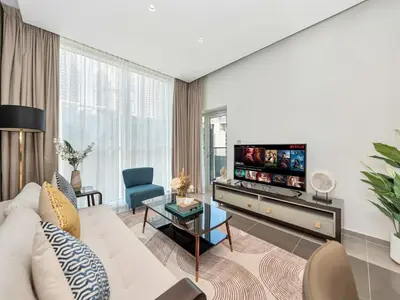a living room with a couch and a tv at NEW Noma Majestine Hotel Style Apt Business Bay in Dubai