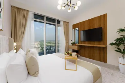 a bedroom with a large white bed and a tv at Maison Privee - Tranquil Living with Golf Course Vws in Dubai Hills in Dubai