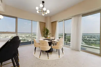 a dining room with a table and chairs and large windows at Maison Privee - Tranquil Living with Golf Course Vws in Dubai Hills in Dubai