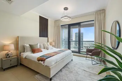 a bedroom with a bed and a large window at HAVN - High Floor 1 bedroom in JLT in Dubai