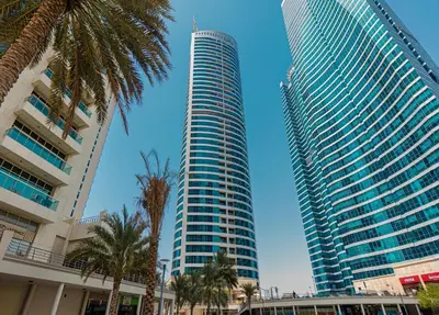 two tall buildings in a city with palm trees at HAVN - High Floor 1 bedroom in JLT in Dubai