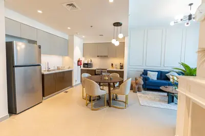 a kitchen and living room with a table and a refrigerator at HAVN - High Floor 2 bedroom in Downtown in Dubai
