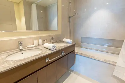 a bathroom with a sink and a mirror and a tub at HAVN - High Floor 2 bedroom in Downtown in Dubai