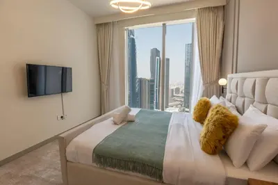 a bedroom with a large bed with a large window at HAVN - High Floor 2 bedroom in Downtown in Dubai