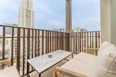 a balcony with a table and chairs on a balcony at Elegant 1BR, Easy Access to Creek Harbour Night Vision - Summer at Creek Beach Building 3 by Deluxe Holiday Homes in Dubai