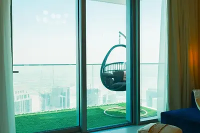 a person sitting in a swing in a window at HAVN - High Floor 2 bedroom in The Grand in Dubai