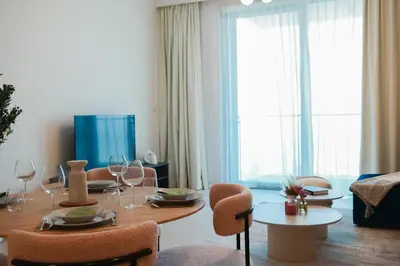 a living room with a table with chairs and a dining room at HAVN - High Floor 2 bedroom in The Grand in Dubai
