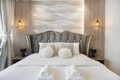 a bedroom with a white bed with two fuzzy pillows at Famous Sky Pool at Paramount's King's 2BR in Dubai