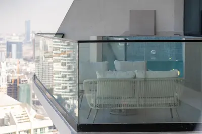 a balcony with a couch and pillows on a building at High-Floor Apartment with Balcony Pool in Dubai