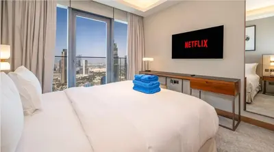 a hotel room with a bed and a desk with a television at Prestige 3Bed with Full Iconic Burj Khalifa Views in Dubai