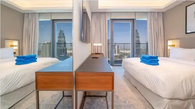 a hotel room with two beds and a desk with a window at Prestige 3Bed with Full Iconic Burj Khalifa Views in Dubai