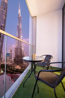 a table and chairs on a balcony with a view of a city at Burj Khalifa Front Ultra Luxe Designer Residence in Dubai