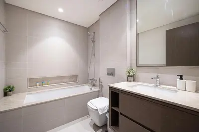 a bathroom with a tub and a toilet and a sink at Burj Khalifa Front Ultra Luxe Designer Residence in Dubai