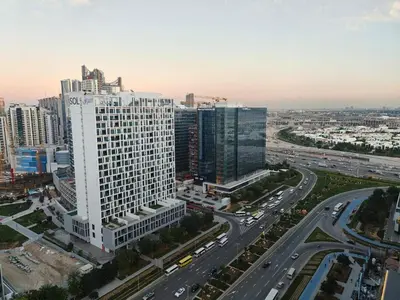 an aerial view of a large white building in a city at High-Floor Luxe 1BR - Burj Khalifa View - Business Bay in Dubai