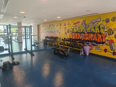 a gym with dumbbells and a wall covered in graffiti at High-Floor Luxe 1BR - Burj Khalifa View - Business Bay in Dubai