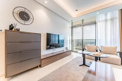 a living room with a large tv and a couch at High-Floor 2BR with Vibrant Street Views and Effortless Drive Access to Downtown Hotspots, Nobles Tower, Business Bay by Deluxe Holiday Homes in Dubai