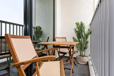 a table and chairs on a balcony with plants at Stylish 1BR Sobha The Crest Pool & City View in Dubai