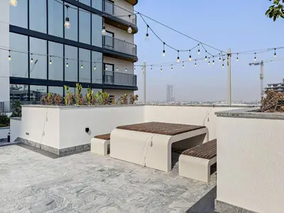 a building with two beds on a patio at Stylish 1BR Sobha The Crest Pool & City View in Dubai