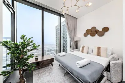 a bedroom with a bed and large windows at Stylish 1BR Sobha The Crest Pool & City View in Dubai